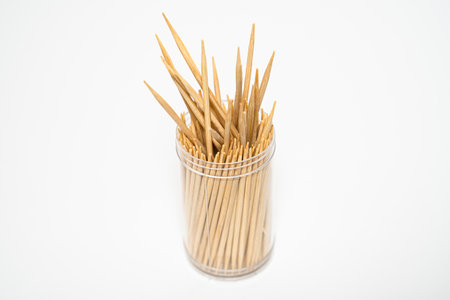 Wooden toothpicks sticking out plastic jar isolated white backgroundの写真素材