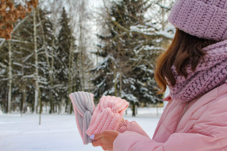 Knitted womens headbands of different colors in hands outdoors