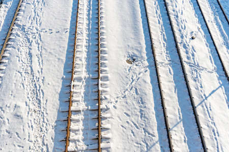 Train station, trains tracks, rails in the snow at sunsetの写真素材