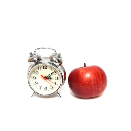 Red apple and clock isolated on white background, time conceptの写真素材