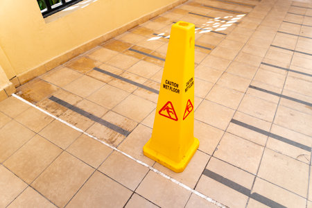 Safety sign with phrase Caution wet floor on road at the tropical resort. Cleaning service slippers.の写真素材