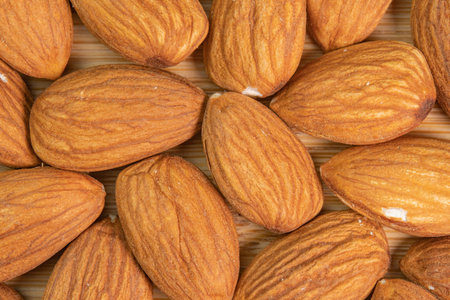 Almond nuts on wooden background close up. Product rich in minerals and vitamins. Almond kernels....