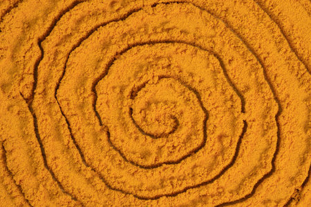 Spiral poured turmeric powder spice background. Dry seasoning turmeric. Spices and herbs for cooking, curcumaの写真素材