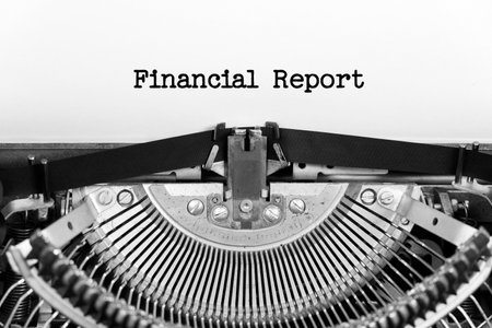Financial Report phrase close up being typing and centered on a sheet of paper on old vintage typewriter mechanicalの写真素材