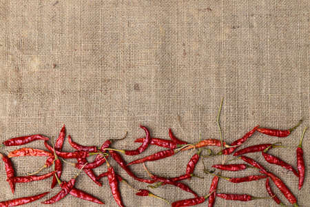 Several ripe organic tasty dried capia peppers with a jute bag backgroundの写真素材
