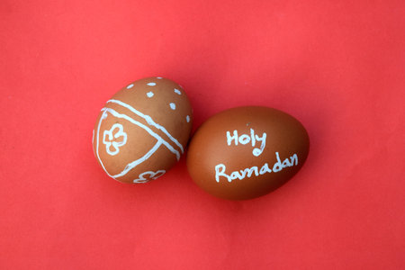 Holy Ramadan hand typography on the egg. Red isolated background.