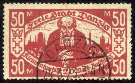 DANZIG - CIRCA 1923 A postage Stamp printing in Free City of Danzig (later Germany, now Gdansk, Poland) shows pensioner against the backdrop of the city , circa 1923のeditorial素材