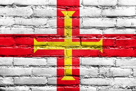 Flag of Guernsey, painted on brick wallの写真素材