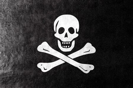 The traditional Jolly Roger of piracy Flag, painted on leather textureの写真素材