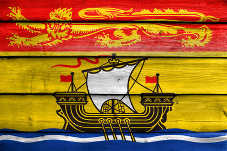 Flag of New Brunswick Province, Canada, painted on old wood plank backgroundの写真素材