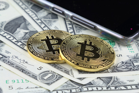 Physical version of Bitcoin (new virtual money) on banknotes of one dollar. Exchange bitcoin cash for a dollar. Conceptual image for worldwide cryptocurrency and digital payment system.の写真素材
