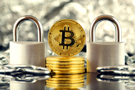 Physical version of Bitcoin (new virtual money), two silver padlocks and chain. Prohibition of cryptocurrencies, regulations, restrictions or security, protection, privacy.の写真素材