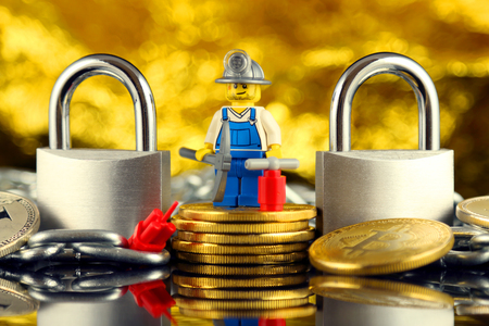 WROCLAW, POLAND - FEBRUARY 17, 2018: Physical version of Bitcoin, miner (as Lego figure), two silver padlocks and chain. Studio shot.のeditorial素材