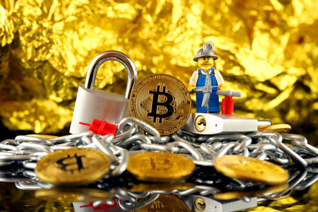 WROCLAW, POLAND - FEBRUARY 17, 2018: Physical version of Bitcoin, miner (as Lego figure), two silver...