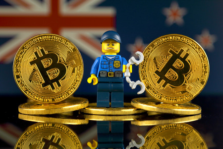 WROCLAW, POLAND - MARCH 10, 2018: Physical version of Bitcoin, Police Officer (as Lego figure) and New Zealand Flag. Studio shot.のeditorial素材