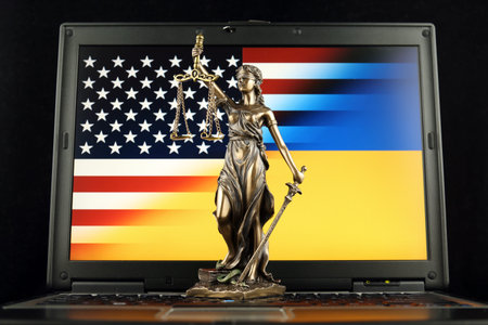 Symbol of law and justice with United States and Ukraine Flag on laptop. Studio shot.