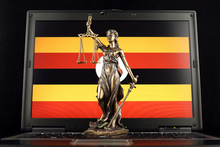 Symbol of law and justice with Uganda Flag on laptop. Studio shot.の写真素材