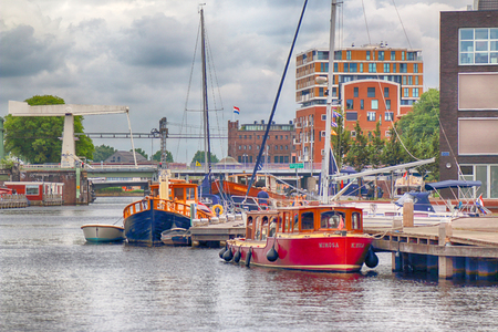 HAARLEM, NETHERLANDS - JULY 09, 2018 : Canal with boats in Summer. Modern Dutch architecture.のeditorial素材