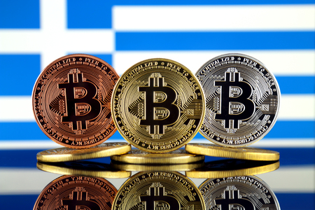 Physical version of Bitcoin (BTC) and Greece Flag. Conceptual image for investors in High Technology (Cryptocurrency, Blockchain Technology, Smart Contracts, ICO).の写真素材