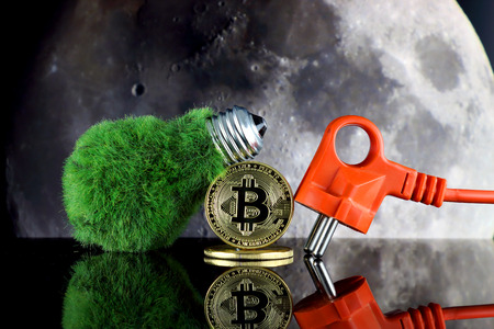 Bitcoin (BTC), the moon and green, renewable energy concept. Electricity prices in the cryptocurrency mining business. The saying TO THE MOON suggests an increase in the value of cryptocurrencies.の写真素材