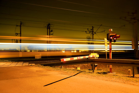 WROCLAW, POLAND - DECEMBER 03, 2019: Railroad crossing with passing train at night, in Siechnice...