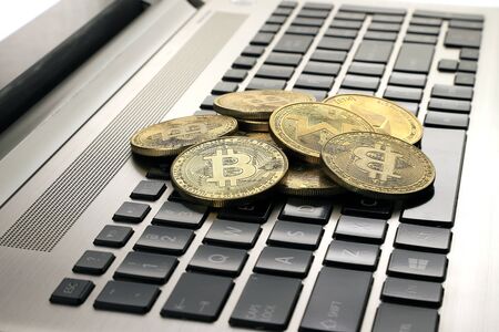Physical version of Bitcoin (BTC) and black laptop keyboard.の写真素材