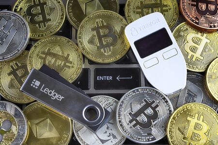 WROCLAW, POLAND - JANUARY 28, 2020: Physical version of Bitcoin (BTC), Trezor and Ledger (cryptocurrency hardware wallets) and enter button.のeditorial素材