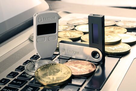 WROCLAW, POLAND - JANUARY 28, 2020: Physical version of Bitcoin (BTC), Trezor and Ledger (cryptocurrency hardware wallets) and black laptop keyboard.のeditorial素材