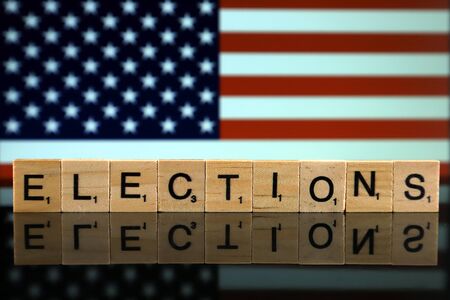 United States Flag and word ELECTIONS made of small wooden letters. Studio shot.の写真素材