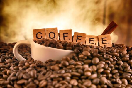 WROCLAW, POLAND - FEBRUARY 05, 2020: White porcelain cup in coffee grains, and word COFFEE made of small wooden letters. Conceptual image for lovers of delicious coffee.のeditorial素材