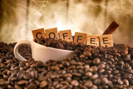 WROCLAW, POLAND - FEBRUARY 05, 2020: White porcelain cup in coffee grains, and word COFFEE made of small wooden letters. Conceptual image for lovers of delicious coffee.のeditorial素材