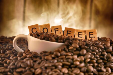 WROCLAW, POLAND - FEBRUARY 05, 2020: White porcelain cup in coffee grains, and word COFFEE made of small wooden letters. Conceptual image for lovers of delicious coffee.のeditorial素材