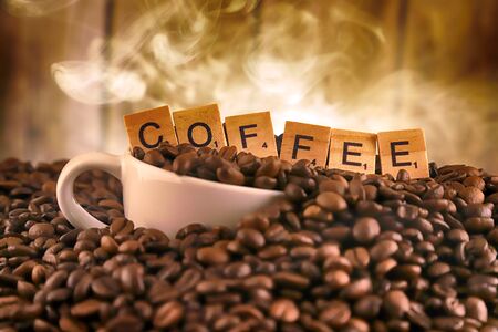 WROCLAW, POLAND - FEBRUARY 05, 2020: White porcelain cup in coffee grains, and word COFFEE made of small wooden letters. Conceptual image for lovers of delicious coffee.のeditorial素材