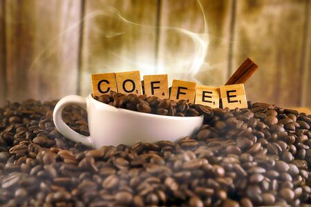 WROCLAW, POLAND - FEBRUARY 05, 2020: White porcelain cup in coffee grains, and word COFFEE made of small wooden letters. Conceptual image for lovers of delicious coffee.のeditorial素材