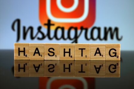 WROCLAW, POLAND - FEBRUARY 12, 2020: Word HASHTAG made of small wooden letters, and INSTAGRAM logo in the background. Studio shot.のeditorial素材