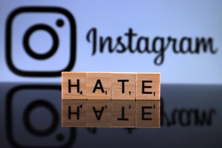WROCLAW, POLAND - FEBRUARY 12, 2020: Word HATE made of small wooden letters, and INSTAGRAM logo in the background. Studio shot.のeditorial素材