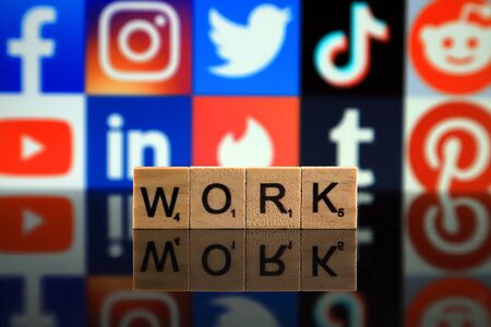 WROCLAW, POLAND - FEBRUARY 12, 2020: Word WORK made of small wooden letters, and FACEBOOK, INSTAGRAM, TWITTER, TIK TOK, REDDIT, YOUTUBE, LINKEDIN, TINDER, TUMBLR, PINTEREST logos in the backgroundのeditorial素材