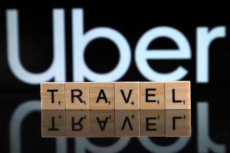 WROCLAW, POLAND - FEBRUARY 19, 2020: Word TRAVEL made of wooden letters, and UBER logo in the background.のeditorial素材