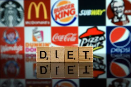 WROCLAW, POLAND - FEBRUARY 19, 2020: Word DIET made of wooden letters, and STARBUCKS, McDONALDS, BURGER KING, SUBWAY, KFC, WENDY'S, DUNKIN DONUTS, COCA COLA, PIZZA HUT, PEPSI logos in backgroundのeditorial素材