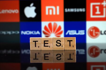 WROCLAW, POLAND - FEBRUARY 19, 2020: Word TEST made of wooden letters, and LENOVO, APPLE, XIAOMI, SAMSUNG, ONEPLUS, OPPO, NOKIA, HUAWEI, ASUS, LG logos in the background.のeditorial素材