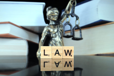 WROCLAW, POLAND - FEBRUARY 28, 2020: The word LAW made of scrabble letters, and symbol of law and...
