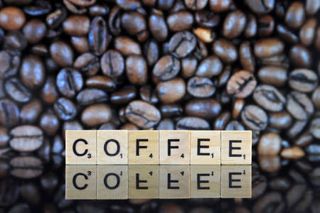 WROCLAW, POLAND - FEBRUARY 28, 2020: Word COFFEE made of scrabble letters, and hole coffee grains in the background. Conceptual image for lovers of delicious coffee.のeditorial素材