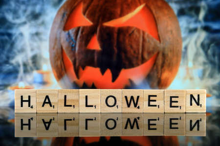 WROCLAW, POLAND - FEBRUARY 28, 2020: The word HALLOWEEN made of scrabble letters, and Halloween pumpkin in the background. Studio shot.のeditorial素材