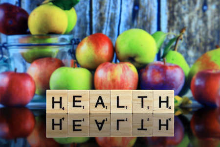 WROCLAW, POLAND - FEBRUARY 28, 2020: The word HEALTH made of scrabble letters, and fresh, real apples from organic farming, ecological harvest on wood background.のeditorial素材