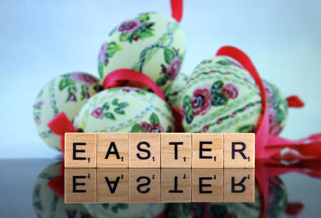 WROCLAW, POLAND - FEBRUARY 28, 2020: The word EASTER made of scrabble letters, and beautiful Easter eggs in the background. Studio shot.のeditorial素材