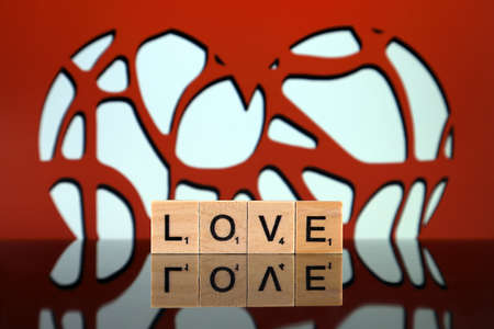 WROCLAW, POLAND - FEBRUARY 28, 2020: The word LOVE made of scrabble letters and one heart in the background. Studio shot.のeditorial素材