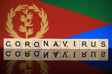 WROCLAW, POLAND - MARCH 28, 2020: Word CORONAVIRUS made of wooden letters, and Eritrea Flag in the...