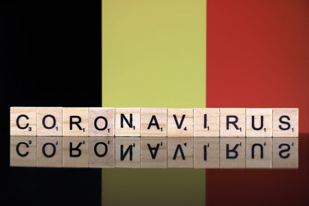 WROCLAW, POLAND - MARCH 28, 2020: Word CORONAVIRUS made of wooden letters, and Belgium Flag in the...