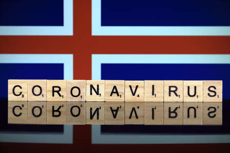 WROCLAW, POLAND - MARCH 28, 2020: Word CORONAVIRUS made of wooden letters, and Iceland Flag in the background. Coronavirus (COVID-19) global disease 2020.のeditorial素材