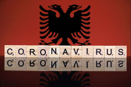 WROCLAW, POLAND - MARCH 28, 2020: Word CORONAVIRUS made of wooden letters, and Albania Flag in the background. Coronavirus (COVID-19) global disease 2020.のeditorial素材